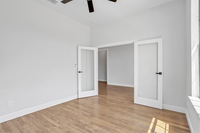 unfurnished room featuring baseboards, light wood-style floors, and a ceiling fan