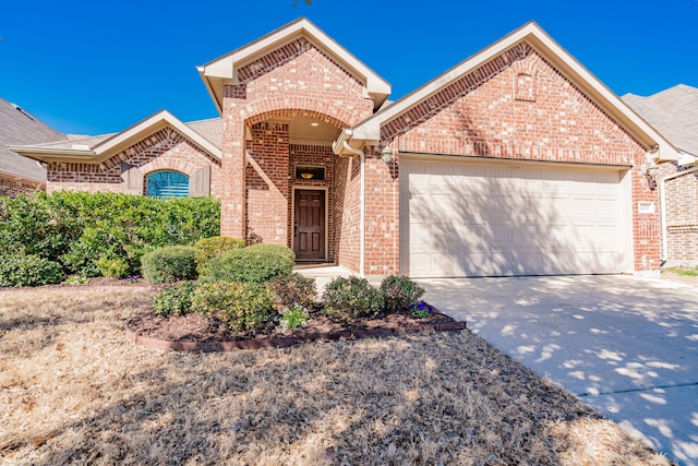 view of front of house featuring brick siding, driveway, and an attached garage