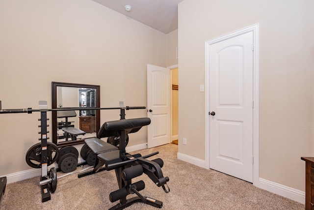 workout area featuring light carpet, high vaulted ceiling, and baseboards