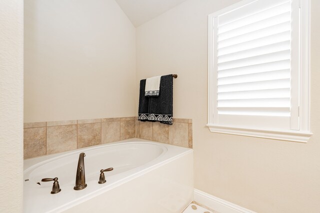 bathroom with baseboards and a garden tub