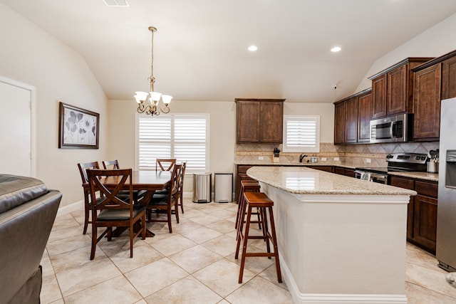 kitchen featuring dark brown cabinets, appliances with stainless steel finishes, and lofted ceiling