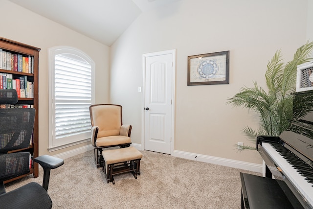 living area featuring vaulted ceiling, light colored carpet, and baseboards