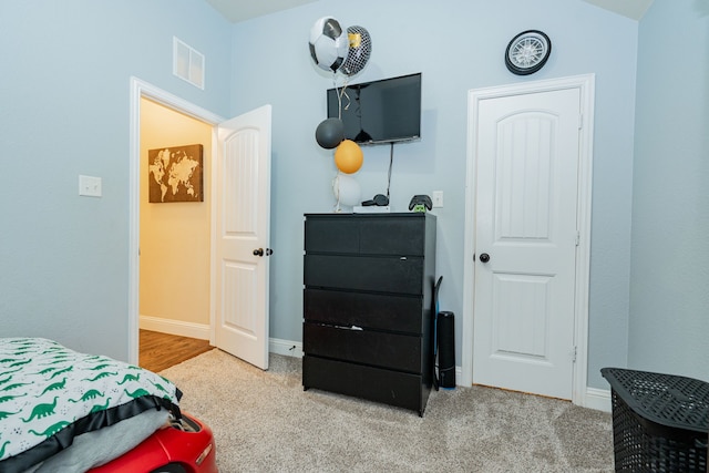 bedroom featuring visible vents, baseboards, and carpet