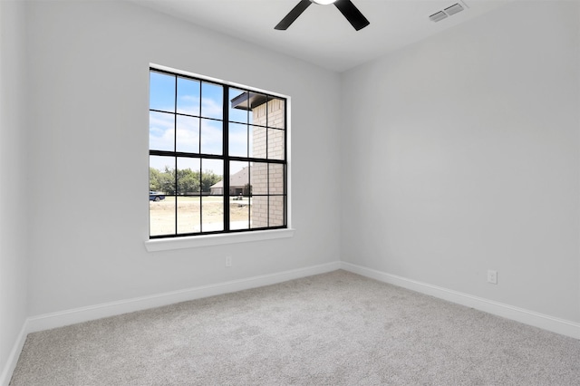 carpeted empty room featuring visible vents, baseboards, and a ceiling fan