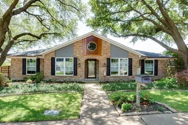 view of front of home with brick siding and a front yard