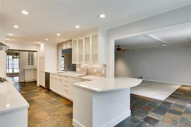 kitchen with white cabinetry, glass insert cabinets, tasteful backsplash, and a sink