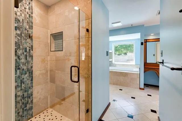 full bathroom with tile patterned floors, a bath, and a stall shower