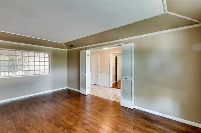 empty room with baseboards and hardwood / wood-style floors