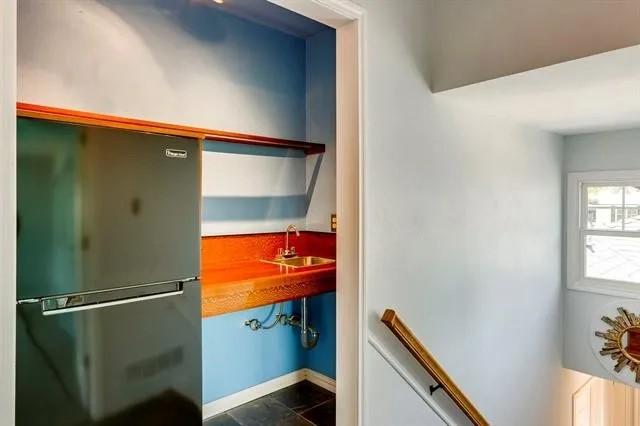 interior space with baseboards, freestanding refrigerator, and a sink