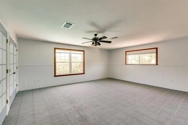 empty room with a ceiling fan and visible vents