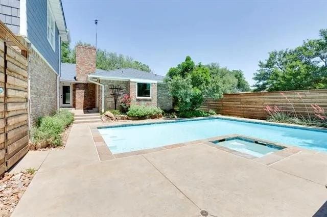 view of pool with a fenced in pool, an in ground hot tub, a patio, and fence