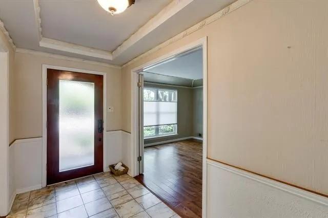 entrance foyer featuring a tray ceiling and ornamental molding