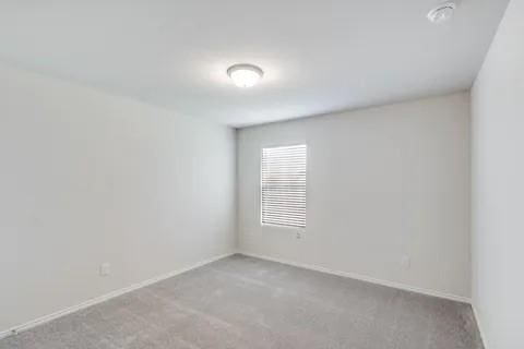 unfurnished room with carpet flooring and baseboards