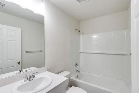 bathroom featuring vanity, toilet, bathtub / shower combination, and visible vents