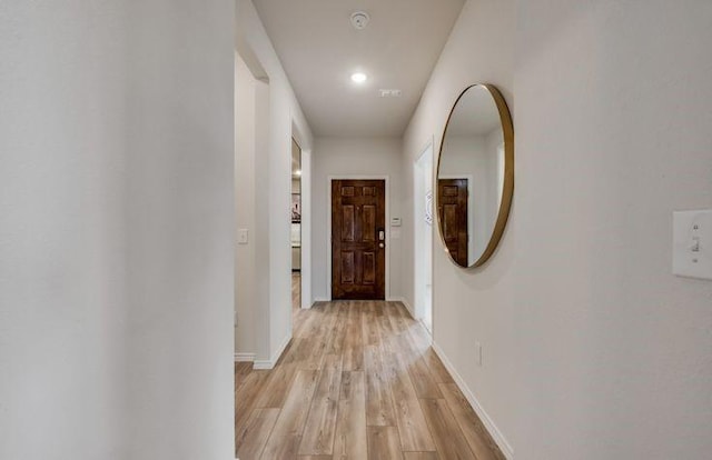 hallway with baseboards and light wood-style flooring