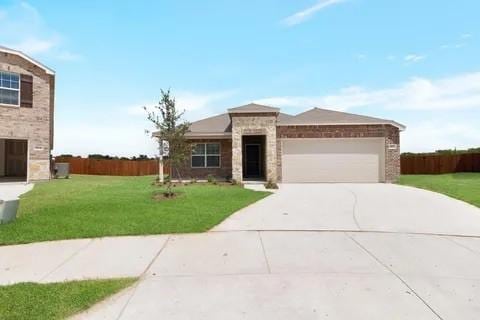 view of front facade with an attached garage, concrete driveway, a front lawn, and fence