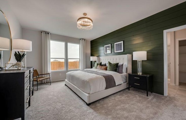 carpeted bedroom featuring an inviting chandelier and wood walls