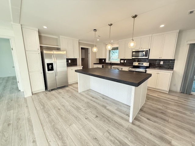 kitchen with a sink, stainless steel appliances, dark countertops, and backsplash