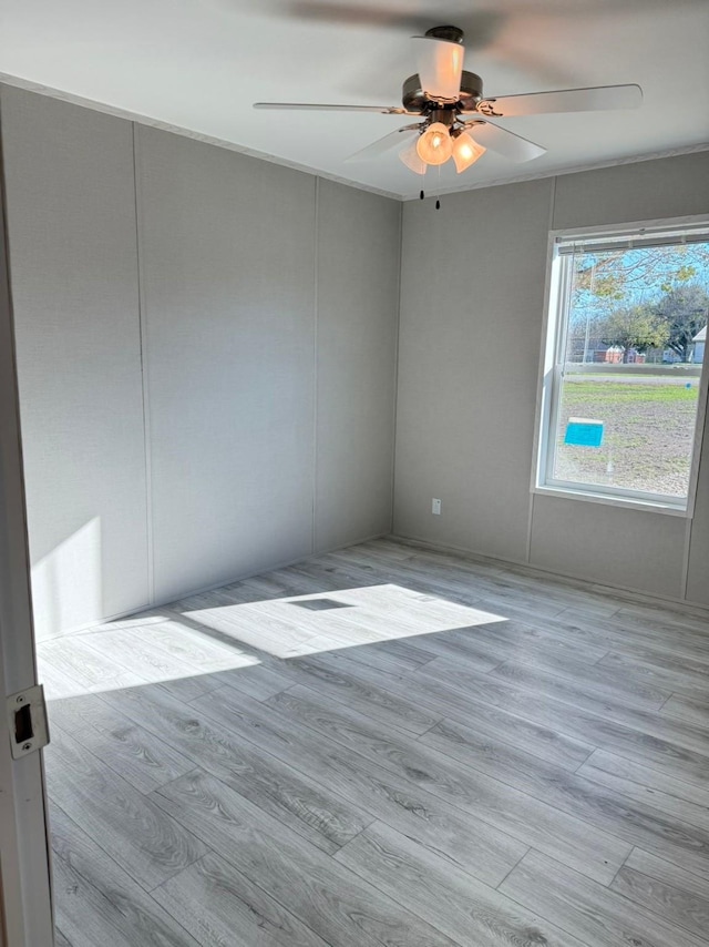 empty room with a ceiling fan and wood finished floors