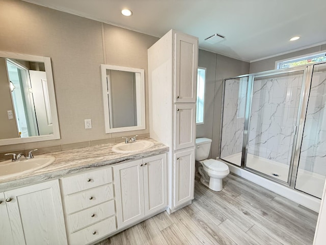 full bathroom featuring a marble finish shower, wood finished floors, toilet, and a sink