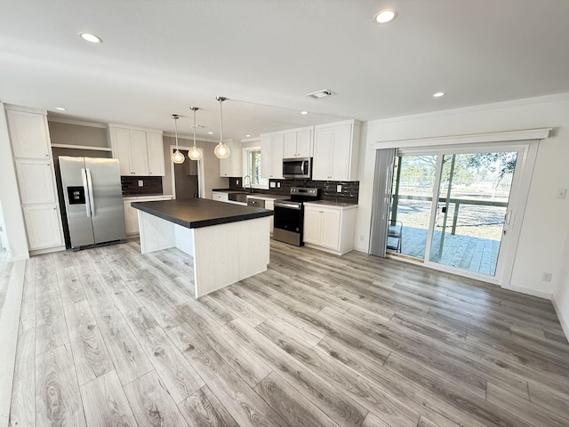 kitchen with dark countertops, visible vents, backsplash, light wood-type flooring, and appliances with stainless steel finishes