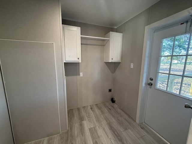 laundry area featuring cabinet space, light wood-type flooring, a wealth of natural light, and electric dryer hookup