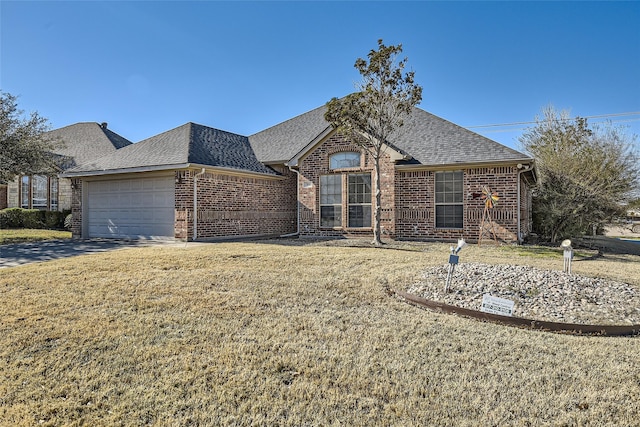 view of front facade featuring brick siding, a front lawn, a garage, and roof with shingles