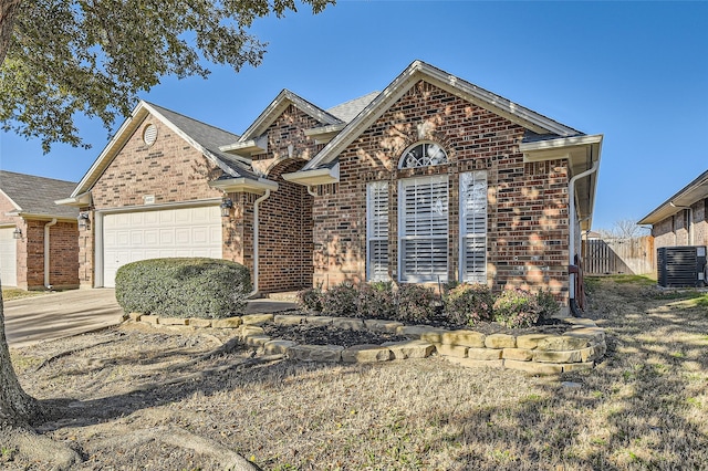 ranch-style house with central air condition unit, brick siding, an attached garage, and fence