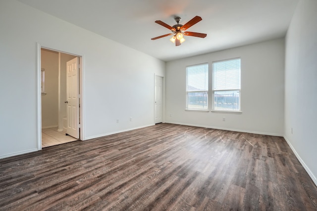 empty room with a ceiling fan, wood finished floors, and baseboards