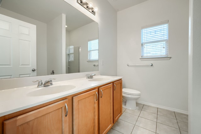 full bath with tile patterned floors, toilet, a stall shower, and a sink