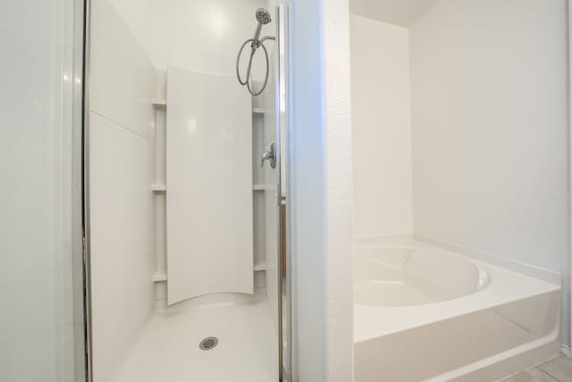 bathroom with a bath and a shower stall