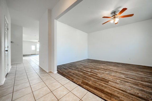 unfurnished room featuring baseboards, light wood-style floors, and ceiling fan