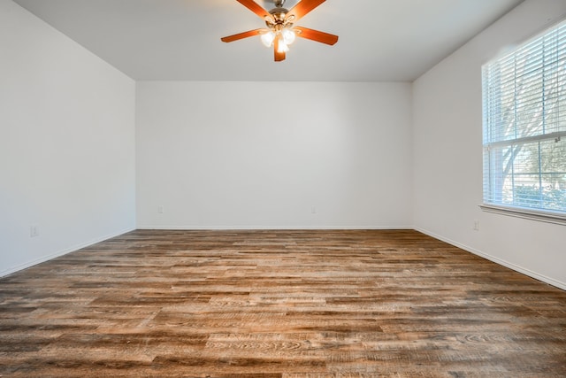 empty room featuring baseboards, a ceiling fan, and wood finished floors