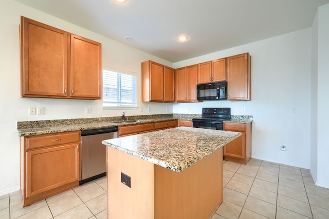 kitchen featuring a kitchen island, light stone counters, light tile patterned floors, black appliances, and a sink