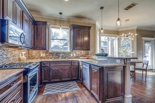 kitchen with dark wood finished floors, visible vents, stainless steel appliances, and a sink