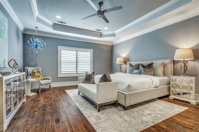 bedroom with visible vents, a tray ceiling, and wood finished floors