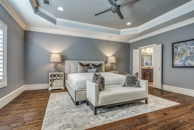 bedroom with a raised ceiling, wood finished floors, baseboards, and ornamental molding