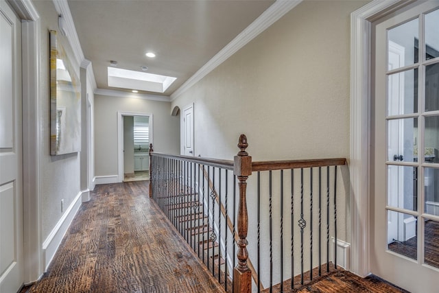 hall with wood finished floors, recessed lighting, a skylight, crown molding, and baseboards