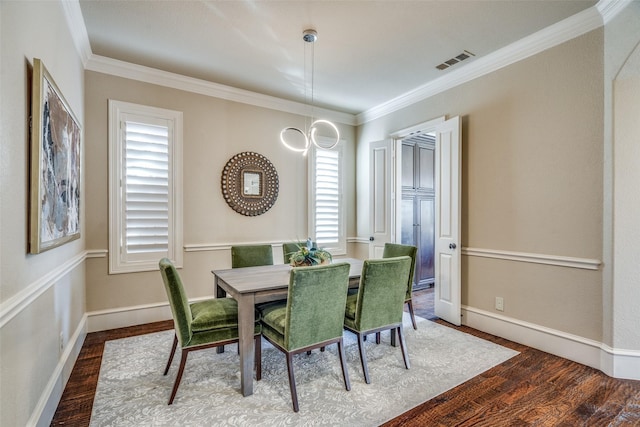 dining room with wood finished floors, visible vents, and ornamental molding