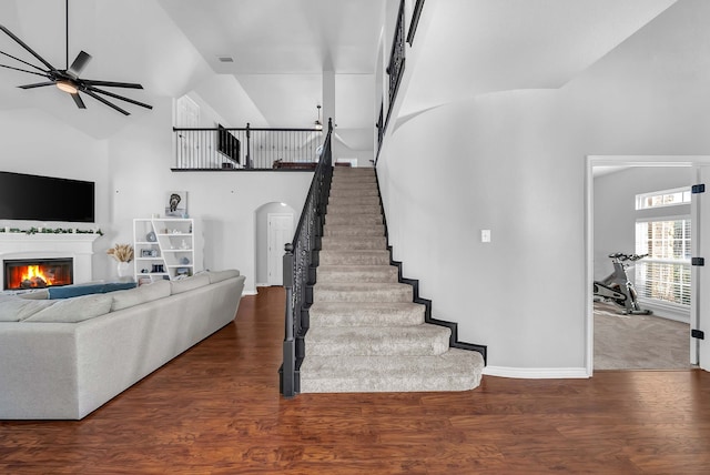 1416 Fence Post Dr, Fort Worth, TX 76052 - living room with high vaulted ceiling, arched walkways, a ceiling fan, a lit fireplace, and baseboards