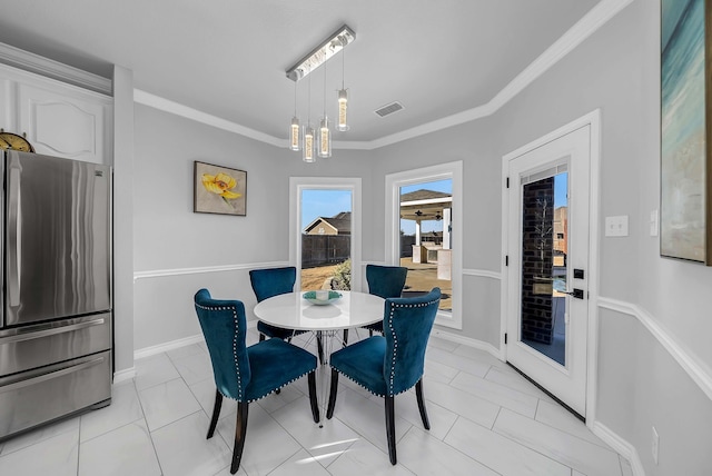 dining room featuring wine cooler, baseboards, visible vents, and ornamental molding