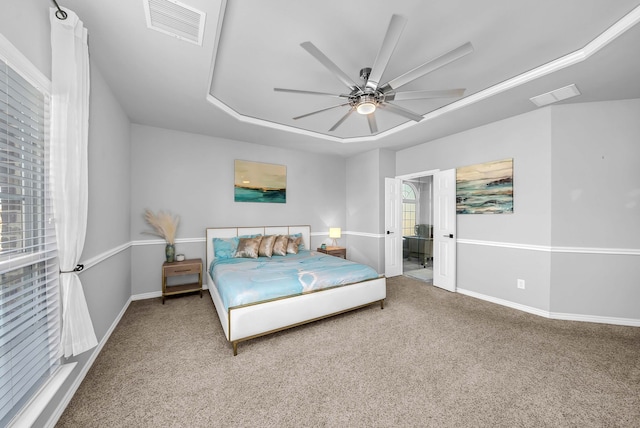 carpeted bedroom with visible vents, a ceiling fan, and baseboards