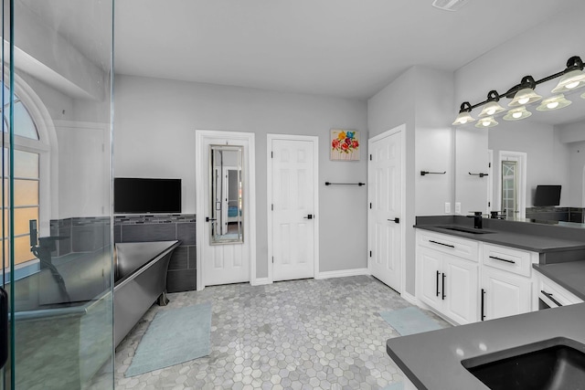 bathroom with vanity, tile walls, a freestanding tub, and visible vents