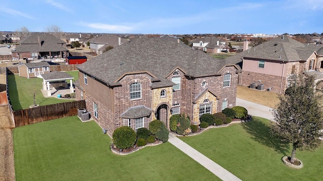 view of front of home with a residential view, brick siding, a front lawn, and a shingled roof