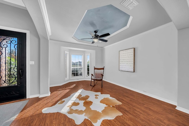 1416 Fence Post Dr, Fort Worth, TX 76052 - living area featuring a raised ceiling, arched walkways, ceiling fan, wood finished floors, and ornamental molding