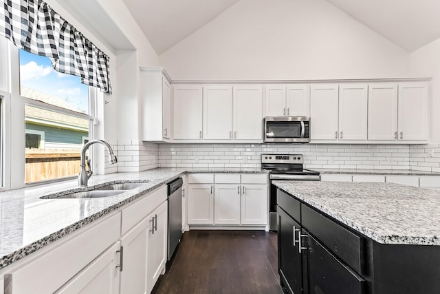 kitchen with a sink, dark cabinetry, white cabinetry, stainless steel appliances, and dark wood-style flooring