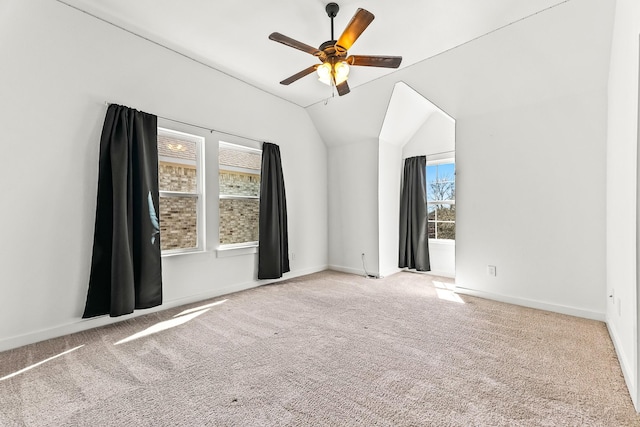 carpeted spare room with baseboards, a ceiling fan, and vaulted ceiling