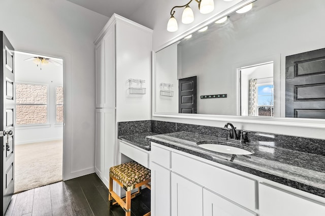 bathroom featuring baseboards, plenty of natural light, wood finished floors, and vanity