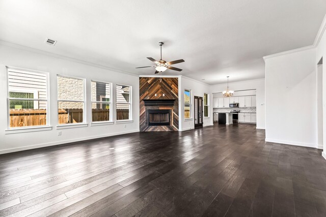 213 E 5th St, Ferris, TX 75125 - unfurnished living room featuring ceiling fan, a fireplace, plenty of natural light, ornamental molding, and dark wood-style floors