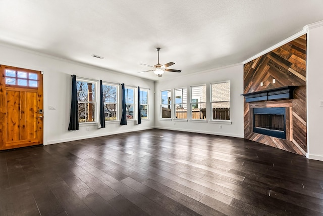 unfurnished living room featuring baseboards, a healthy amount of sunlight, dark wood-style flooring, and a tiled fireplace